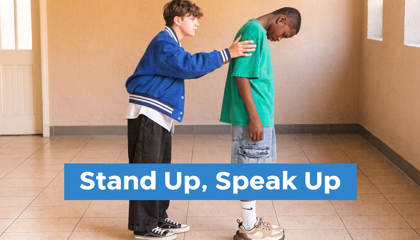 A teenager in a blue jacket comforting a classmate who is looking down, highlighting anti-bullying efforts.