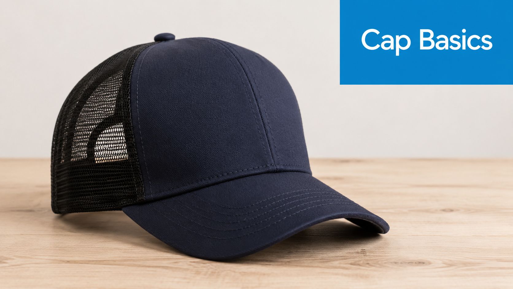 A navy blue baseball cap with a black mesh back sitting on a light wooden table surface.