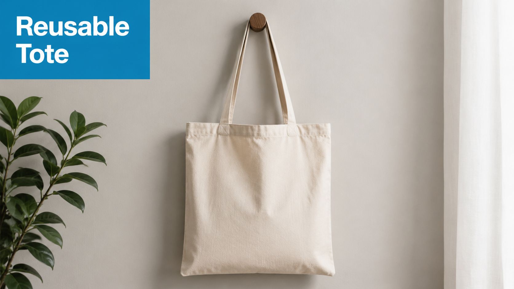 A blank beige canvas tote bag hanging on a wooden hook against a light grey wall.