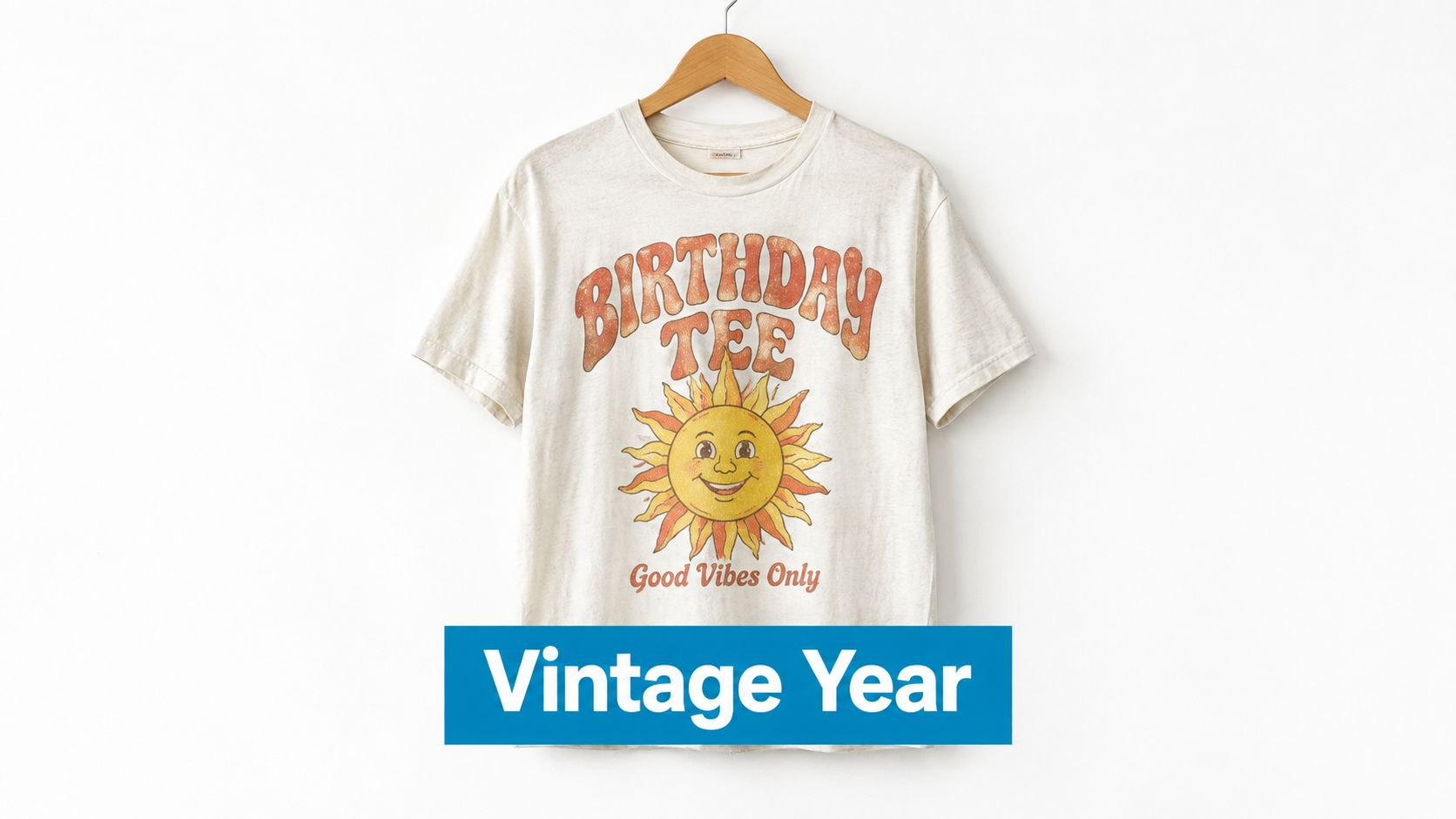 A beige t-shirt on a wooden hanger with a retro style sun graphic and birthday text.