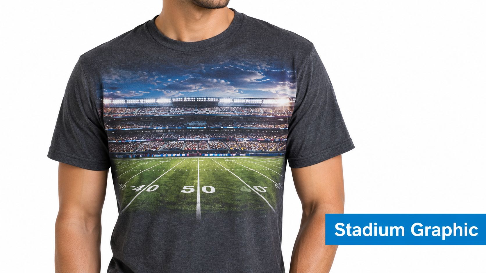 A man wearing a charcoal gray t-shirt featuring a large realistic graphic print of a football stadium.