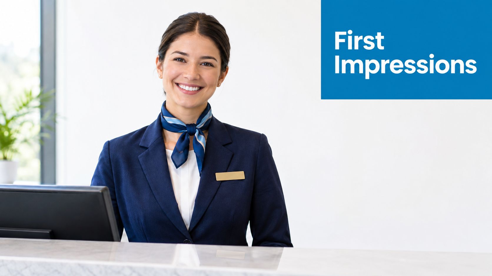 A friendly female receptionist wearing a blue uniform and scarf smiles warmly behind a hotel desk.
